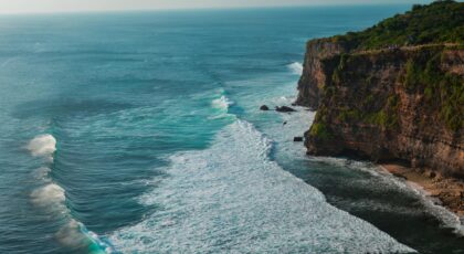 Breathtaking view of towering coastal cliffs with waves crashing in Bali, Indonesia.