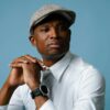Portrait of a stylish man in classic fashion, wearing a flat cap and white shirt.