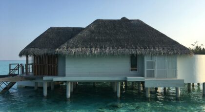 A serene overwater bungalow under a sunny sky, offering a perfect tropical getaway.