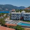 Aerial view of a luxury coastal resort with pool near the sea.
