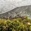 Aerial view of ocean waves crashing on rocks from a cliff in Bali, Indonesia.