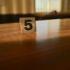 A wooden table with a number 5 card in a softly lit room, capturing the warm ambiance.