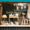 Charming vintage store window showcasing antiques and collectibles in an autumn setting.