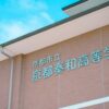 Brick building facade with Japanese text under a clear blue sky in Kyoto, Japan.