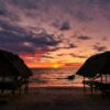 Tranquil beach sunset with cabanas in Koh Kong Province, Cambodia.